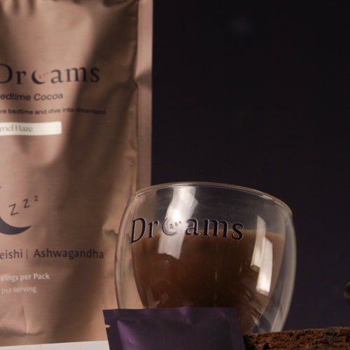 CocoaDreams packaging with a glass of chocolate drink and brownies on a dark background